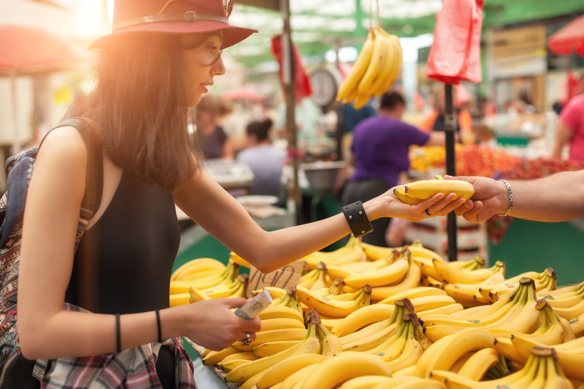 Una donna acquista un casco di banane al mercato